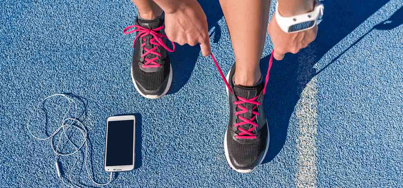 woman doing shoe laces and a phone