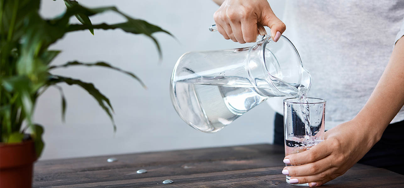 woman pouring water into the glass