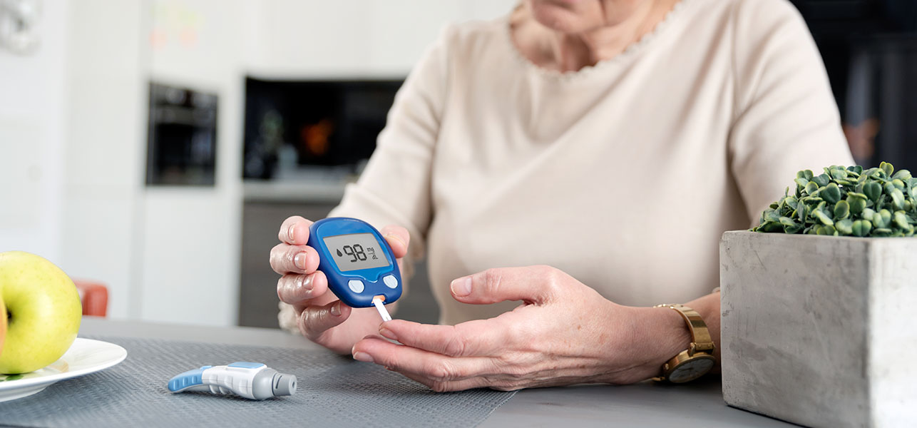 Elder woman measuring sugar level